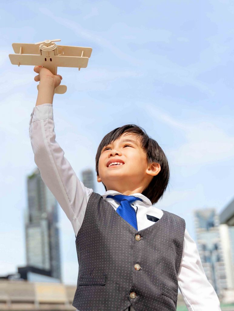 young boy playing aviator toy air plane imagination dreaming of being pilot future on business district urban 772x1024